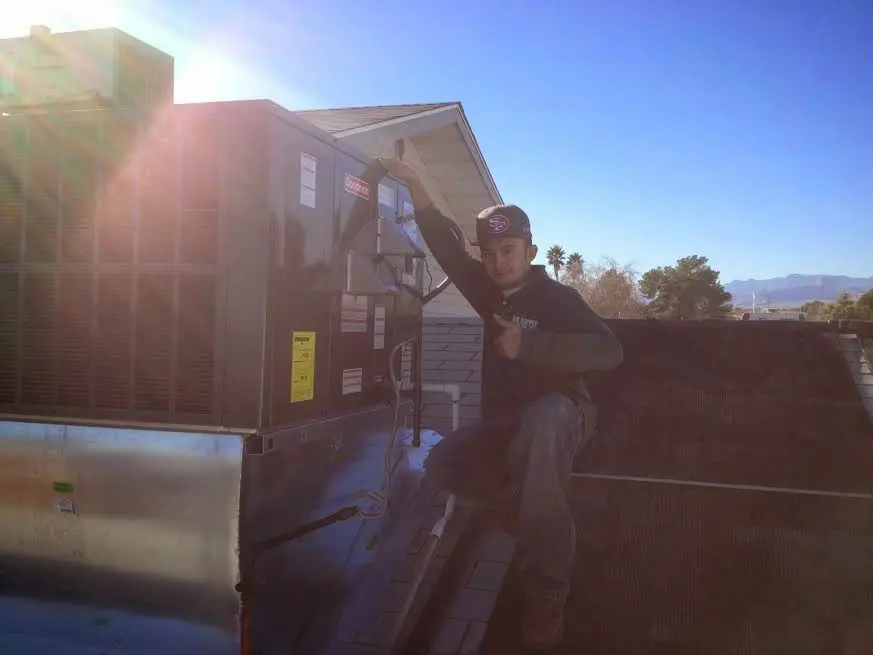 HVAC technician performing Air Duct Repair on a rooftop unit in Endicott